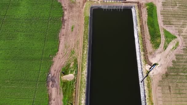 Aero. vista dall'alto. artificiale speciale, piscina di stoccaggio dell'acqua, serbatoio o serbatoio per l'irrigazione campi agricoli. nelle vicinanze si trova una stazione di pompaggio per l'assunzione di acqua. tecnologie moderne nel settore agricolo. — Video Stock