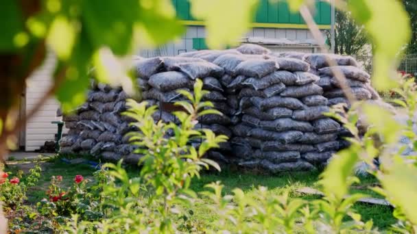 Una gran cantidad de bolsas de polietileno con arcilla expandida apilados uno encima del otro. jardinería. mercado florístico invernadero. floristería, horticultura . — Vídeo de stock