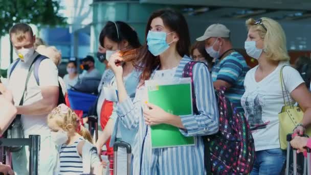 BORISPYL, UCRANIA, 31 DE JULIO DE 2020: en el aeropuerto, personas con máscaras protectoras, con equipaje, haciendo cola en los mostradores de facturación. Apertura de vuelos tras pandemia de coronavirus. — Vídeo de stock