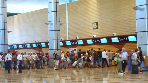 ハルガダ、 EGYPT 、 2020年7月31日:フライトのチェックインカウンターで保護マスクの観光客の長い列。開けろ!。コロナウイルスのパンデミック後の飛行の再開。境界線. — ストック動画