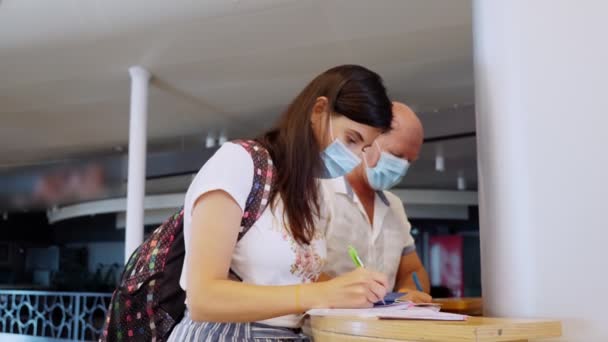 Γυναίκα και άνδρας με προστατευτικές μάσκες, που κατέχουν διαβατήρια και εισιτήρια, συμπληρώνουν έγγραφα, ιατρικά ερωτηματολόγια στο αεροδρόμιο. νέοι κανόνες και περιορισμοί μετά το τέλος της επιδημίας του κορωναϊού. Επανάληψη της — Αρχείο Βίντεο