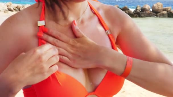 Gros plan, les frottis sexuels de la femme, applique un écran solaire pour décolleter la peau. sur la plage sous le soleil chaud, sur fond de mer. Protection solaire et UV. protection de la peau — Video