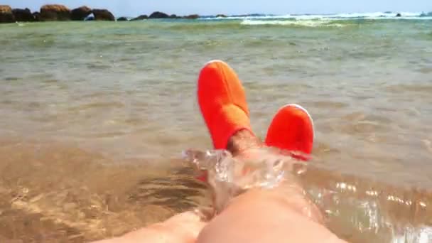 Close-up, female legs in bright orange special water shoes, for swimming in the sea, for not to get hurt on the reefs. sea vacation concept — Stock Video