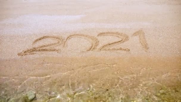 Primo piano, numeri 2021 su sabbia gialla bagnata, sulla spiaggia in riva al mare. — Video Stock