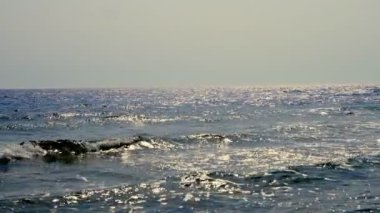 Güzel deniz manzarası. Denizde beyaz köpüklü küçük sörf dalgaları. Yaz manzaralı deniz manzaralı, güneşli bir günde deniz manzaralı.
