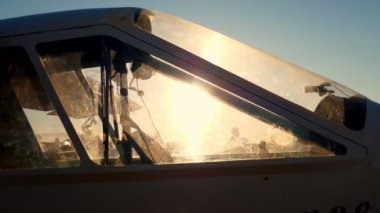 Güneş ışınları günbatımında, bir retro uçağın kokpitinden geçer.