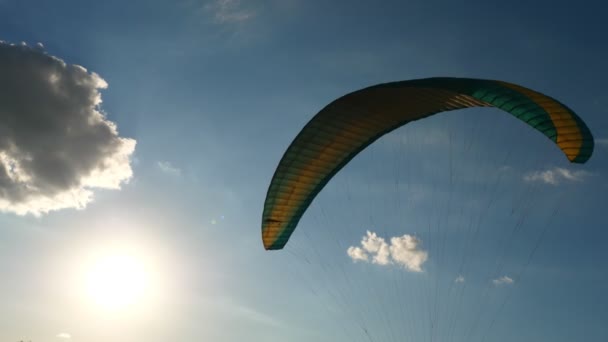 在蓝天、云彩和阳光的映衬下，滑翔伞在风中飘扬的特写 — 图库视频影像