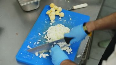 Yemek pişirmek. Yakın plan, koruyucu eldivenli şef, pişirme tahtasında haşlanmış yumurta kesiyor. Sağlıklı gıda ve güvenlik kavramı. Matarayı yeniden aç