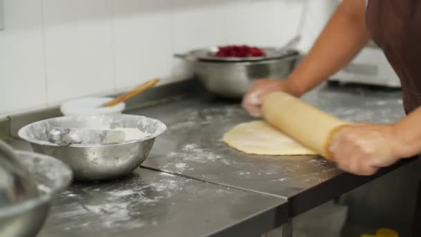 Cuisiner. produits de boulangerie. Gros plan. mains féminines déroulant la pâte sur la table de cuisine, saupoudré de farine. nourriture santé. réouverture de la cantine. bénévolat et charité — Video