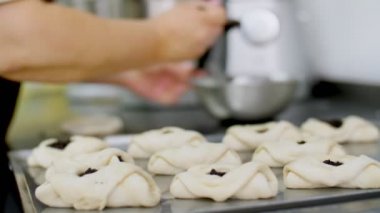 Yemek pişirmek. Fırın ürünleri. Yakın plan. Kadın fırıncı, turta heykeli, haşhaş tohumlu çörekler yapar. Sağlıklı yemek. Gönüllü olmak ve yardım. Matarayı yeniden açıyorum. güvenlik kavramı.