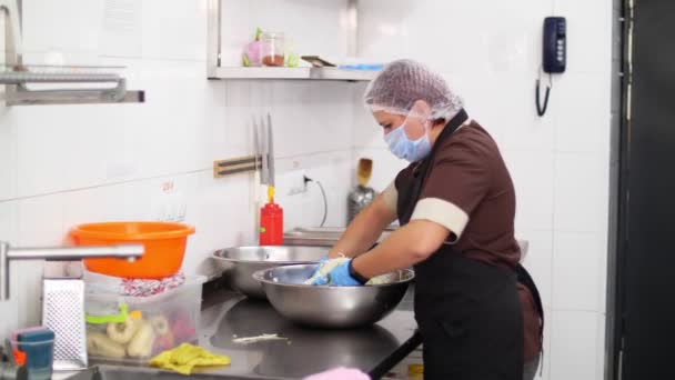 Готувати. шеф-кухар, в захисній масці і рукавичках, готує салат у великій мисці. здорове харчування. концепція безпеки. відновлення їдальні. волонтерства та благодійності — стокове відео