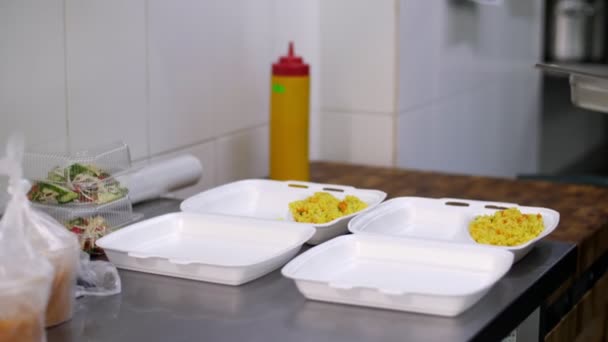 Cucinare. primo piano, Volontariato, in guanti protettivi, confezionare pasti caldi gratuiti in scatole da pranzo, da consegnare ai poveri. consegna di cibo. Progetto di beneficenza, donazione di aiuti, — Video Stock