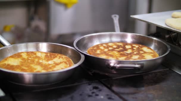 Kochen. Nahaufnahme. große Tortilla, Fladenbrot oder Pfannkuchen in der Pfanne gebraten. gesunde Ernährung. Freiwilligenarbeit und Wohltätigkeit. Wiedereröffnung. Sicherheitskonzept. — Stockvideo