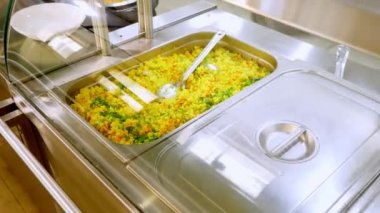 Yemek pişirmek. Yakın plan. Garson koruyucu eldivenlerle konteynırları yemeklerle, cam vitrinlerin arkasında, self servis kafeteryasında ya da açık büfede açar. Sağlıklı yemek. Gönüllülük ve yardım