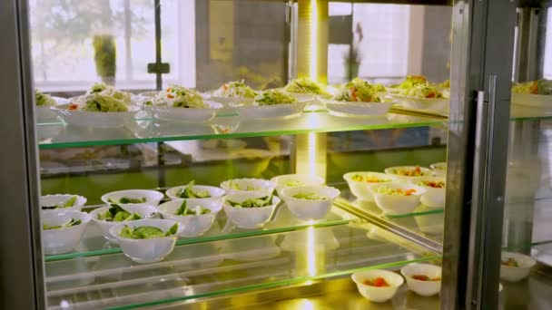 Kamu hizmeti kafeteryasında ya da açık büfede yeni hazırlanmış sebze salatalarının olduğu bir vitrin. Sağlıklı yemek. Gönüllü olmak ve yardım. Yeniden açılıyor. güvenlik kavramı — Stok video