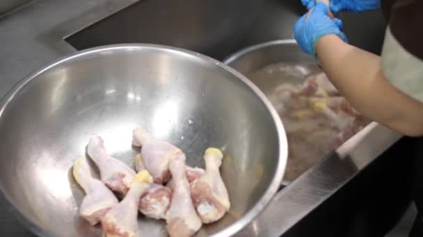 Gros plan. Le cuisinier, dans des gants de protection, lave les cuisses de poulet crues avant la cuisson. nourriture santé. bénévolat et charité. réouverture après covid-19. concept de sécurité. — Video