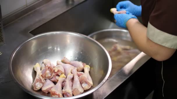 Yakın plan. Mutfak işçisi, koruyucu eldivenlerle, pişirmeden önce çiğ tavuk bacağı yıkar. Sağlıklı yemek. Gönüllü olmak ve yardım. Covid-19 'dan sonra tekrar açılıyor. güvenlik kavramı. — Stok video