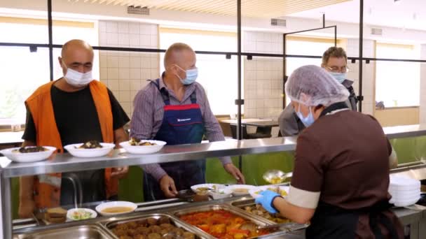 CHERKASSY, UKRAINE, 14 de AGOSTO de 2020: os homens, com máscaras protetoras, almoçam em cafetaria self-service ou restaurante buffet. comida saudável. reabertura. conceito de segurança — Vídeo de Stock