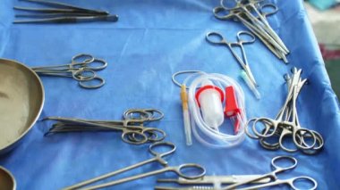 Cerrahi aletler, neşter, pens ve cımbız da dahil olmak üzere çelik tıbbi gereçler tıbbi masada yatıyor. Operasyon için hazırlık. Ameliyat ve acil durum konsepti. covid-19 salgını