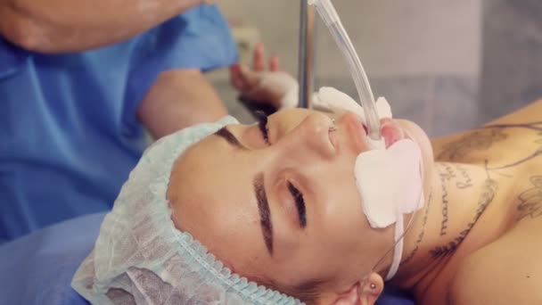 Κοντινό πλάνο. γυναίκα ασθενής, σε κατάσταση αναισθησίας, με σωλήνα στο στόμα, βρίσκεται στο χειρουργικό τραπέζι κατά τη διάρκεια της χειρουργικής επέμβασης. χειρουργείο και εντατική φροντίδα στο νοσοκομείο. — Αρχείο Βίντεο