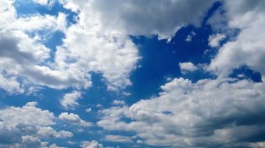 Zaman ayarlı, fantastik beyaz bulutlar. Güzel, kabarık, mavi gökyüzüne karşı akan bulutlar.