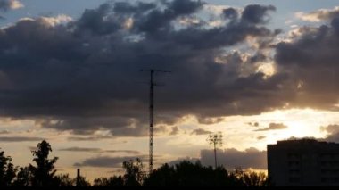 Zaman ayarlı, güzel turuncu gün batımı şehirde. akan gri, yağmur bulutları.