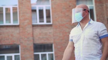 Güvenlik görevlisi, dijital medikal elektronik termometre kullanarak okul binasına girmeden önce kızın vücut ısısını ölçüyor. Covid19 salgınından sonra okula döndüm.