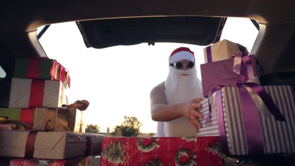 Santa claus delivering gifts. gifts from santa. delivery service. deliveryman loads boxes. gift boxes in car. beautifully wrapped parcels. view from inside the car. donation, charity or delivery — Stock Video