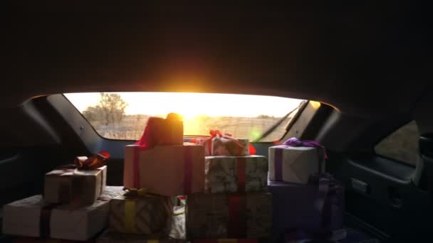 A lot of gifts in the trunk. gift boxes in the car. beautifully wrapped parcels. view from inside the car. delivery service. donation, charity concept. — Stock Video