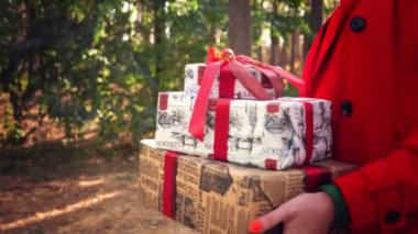 Paketli hediyeler. Kapat. Elinde güzel paketlenmiş kutular tutan bir kadın. Açık havada. Teslimat ya da bağış, bağış konsepti. Tatil için hediyeler