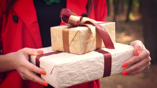 Ingepakte cadeaus. Doe dicht. vrouw met verschillende prachtig verpakte dozen in haar handen. Buiten. levering of donatie, liefdadigheidsconcept. geschenken voor de vakantie — Stockvideo