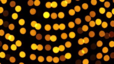 Soyut sahte arkaplan hareket halinde. Parlak, bulanık altın parçacıklar, ışıklar. Koyu arkaplandaki çelenklerden parlak bir bokeh. Yeni yıl ya da Noel arkaplanı.