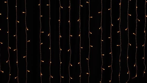 Arany koszorúslámpák fekete háttérrel. Újév vagy Karácsony, sokoldalú ünnepi és varázslatos háttér. — Stock videók