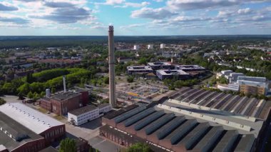 Endüstriyel binaların havadan görünüşü ve Almanya 'nın Hennigsdorf şehrinde bir bacanın yanından geçen bir tren. Hız rampası hiper hareket zaman aşımı ters uçan İHA 