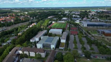 Hennigsdorf Lisesi 'ndeki spor tesisleri arasında futbol sahası, koşu pisti ve yerleşim alanlarındaki diğer binalar da var. geniş yörünge görünümü dronu 