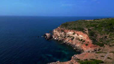 Akdeniz 'in engebeli uçurumlarını ve kristal berrak turkuaz sularını gösteren İbiza kıyı şeridinin hava manzarası. Ters İHA hız rampasında uç. Hiper hareket süresi doluyor. 