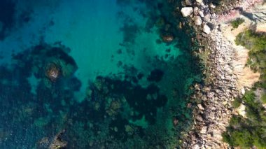 Akdeniz 'in engebeli uçurumlarını ve kristal berrak turkuaz sularını gösteren İbiza kıyı şeridinin hava manzarası. İHA kamerası aşağıya bakıyor 