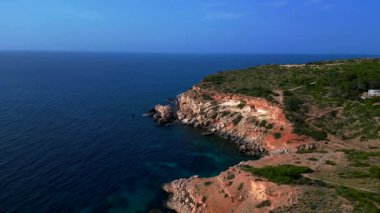 Akdeniz 'in engebeli uçurumlarını ve kristal berrak turkuaz sularını gösteren İbiza kıyı şeridinin hava manzarası. Ters panorama görünümü dronu uçur 