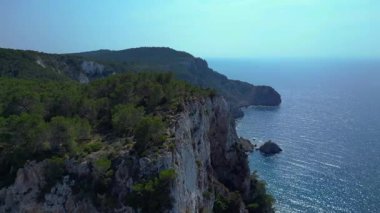 İbiza, İspanya 'da kayalık bir kayalık yüzeyi keşfeden yürüyüşçülerin hava görüntüsü. panorama yörünge dronu 