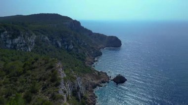 İbiza, İspanya 'da kayalık bir kayalık yüzeyi keşfeden yürüyüşçülerin hava görüntüsü. panorama genel görünüm dronu 