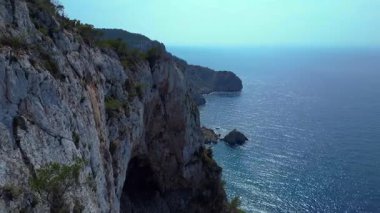 İbiza, İspanya 'da kayalık bir kayalık yüzeyi keşfeden yürüyüşçülerin hava görüntüsü. Çok yakından geçen bir insansız uçak 