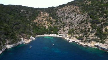Yazın İspanya 'nın İbiza kentindeki güzel Cala Llentrisca sahilinin turkuaz suyu ve Barques de Pescadors Huts manzarası. rotasyon pan 'dan sağ drona 