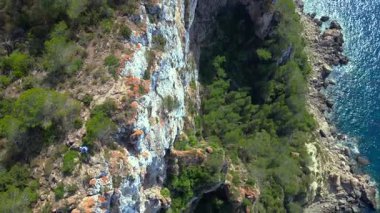 İbiza, İspanya 'da kayalık bir kayalık yüzeyi keşfeden yürüyüşçülerin hava görüntüsü. Drone 'u yukarı eğ 