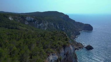 İbiza, İspanya 'da kayalık bir kayalık yüzeyi keşfeden yürüyüşçülerin hava görüntüsü. İHA alçalıyor 