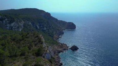 İbiza, İspanya 'da kayalık bir kayalık yüzeyi keşfeden yürüyüşçülerin hava görüntüsü. Ters İHA uçuşu 