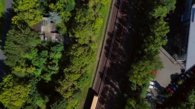 Güneşli bir yaz gününde Berlin, Almanya 'da Tempelhofer Feld' den geçen sarı bir S Bahn treninin hava görüntüsü. Drone 'u yukarı eğ 