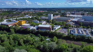 Fabrikaları, otoyolları ve güneşli gökyüzünün altındaki ağaçları olan Berlins sanayi bölgesinin havadan görünüşü. panorama genel görünüm dronu 