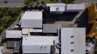 Berlin, Almanya 'daki Tempelhof Ufa Stüdyoları' nın hava görüntülerinde binalar, ağaçlar ve çevre kent manzaraları görülüyor. Aşağıya bakan İHA kamerası yükseliyor 