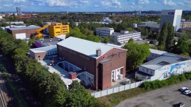 Berlin, Almanya 'daki Tempelhof Ufa Stüdyoları' nın hava görüntülerinde binalar, ağaçlar ve çevre kent manzaraları görülüyor. Ters İHA uçuşu 