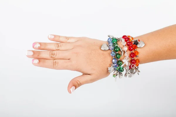 Woman\'s hand wearing jewelry accessory bracelets in neutral background